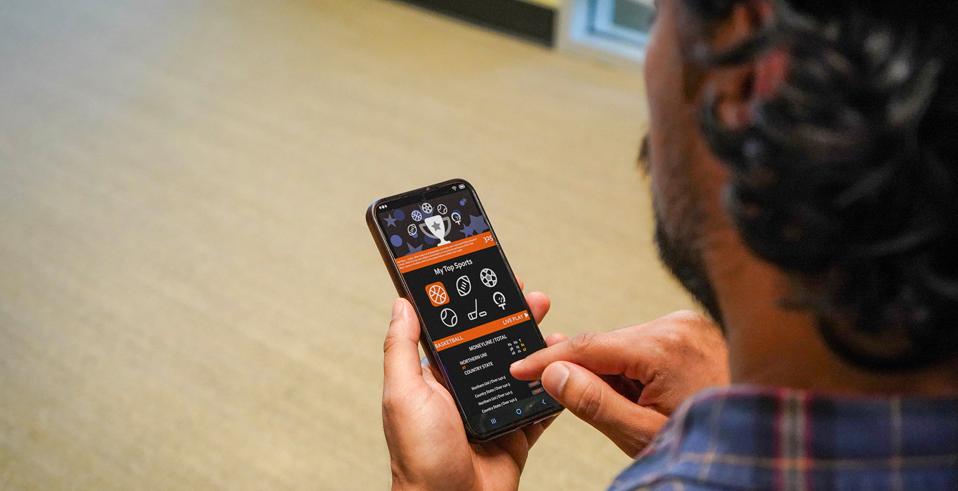 guy-holding-phone-looking-at-game-stats